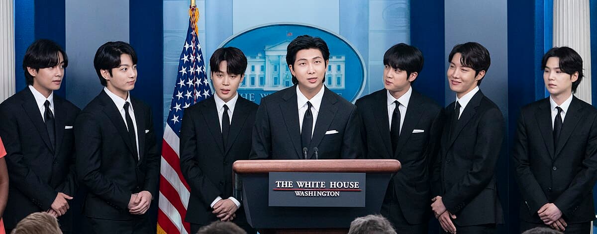 BTS tại Nhà Trắng tháng 5 năm 2022, cả bảy thành viên đứng trong bộ vest đen trang trọng tại một cuộc họp báo
